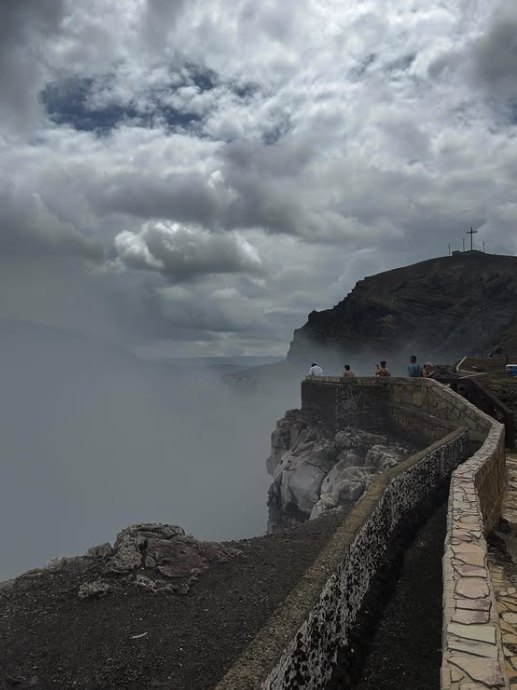 The paved crater-rim walkway at Masaya Volcano disappearing into thick volcanic gas