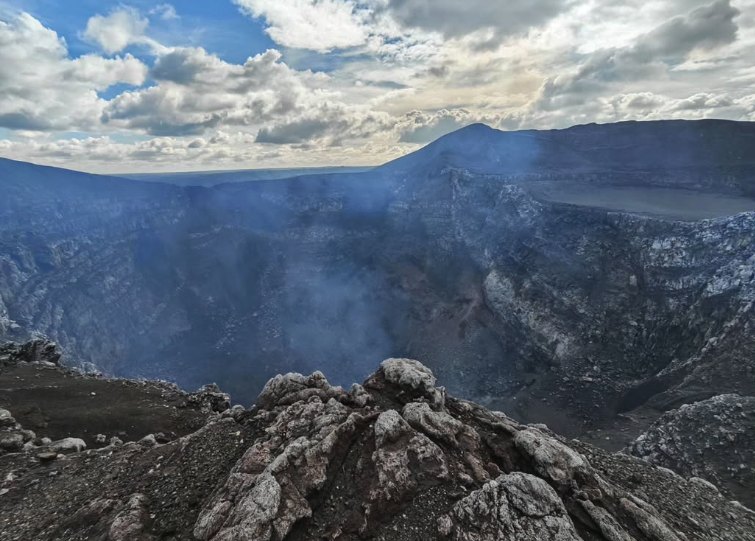 Daytime view across the Masaya Volcano caldera from the rim, with the crater walls stepping away