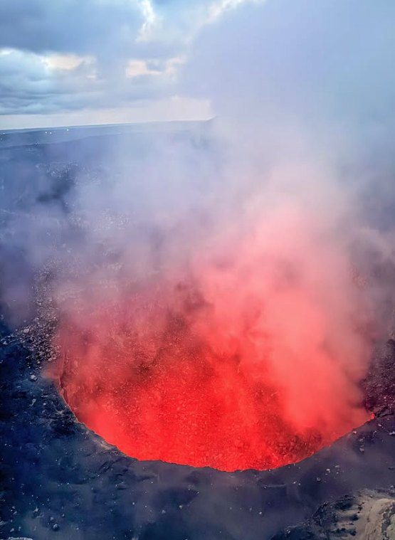 White gas drifting out of the Masaya Volcano crater under an afternoon sky