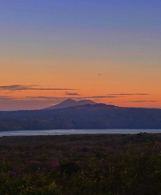 Dusk over the Nicaraguan lowlands from Masaya Volcano, with a distant cone on the horizon